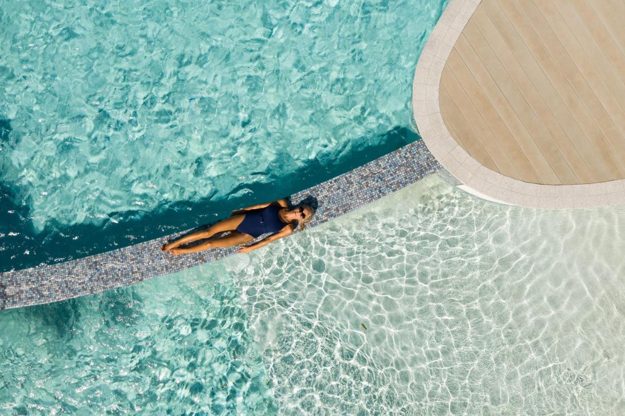 Crystalbrook Riley Hotel Cairns Exterior foto Aerial view of a woman sunbathing in a swimming pool